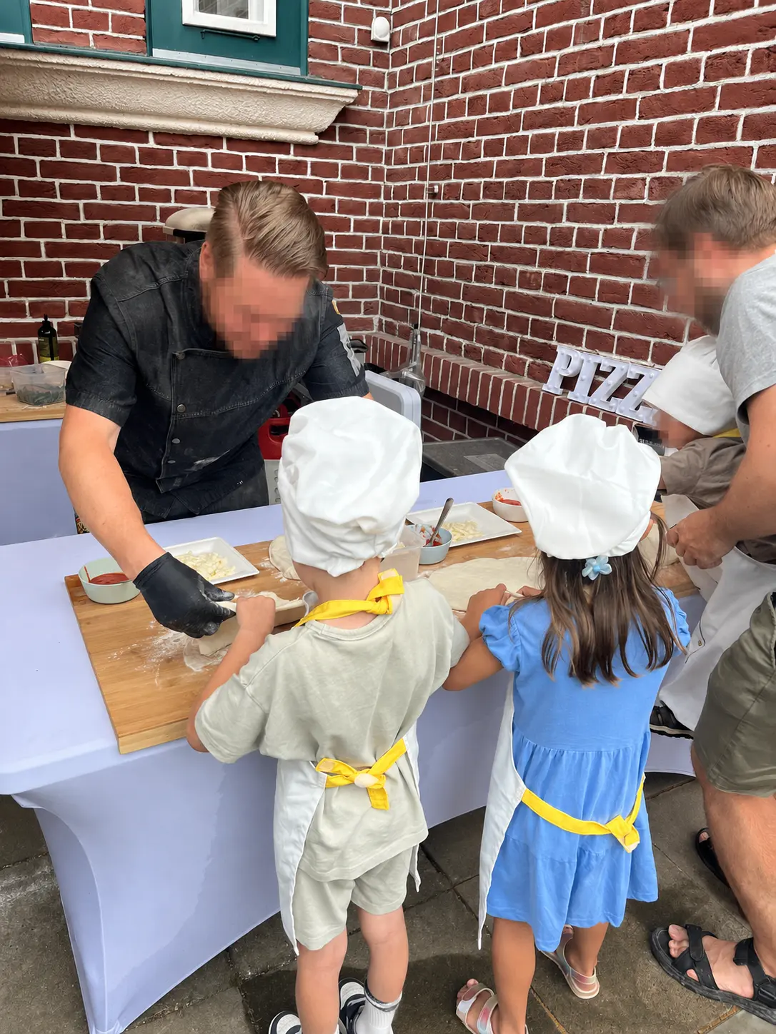 Children making pizza at a workshop; all visible faces have been anonymised